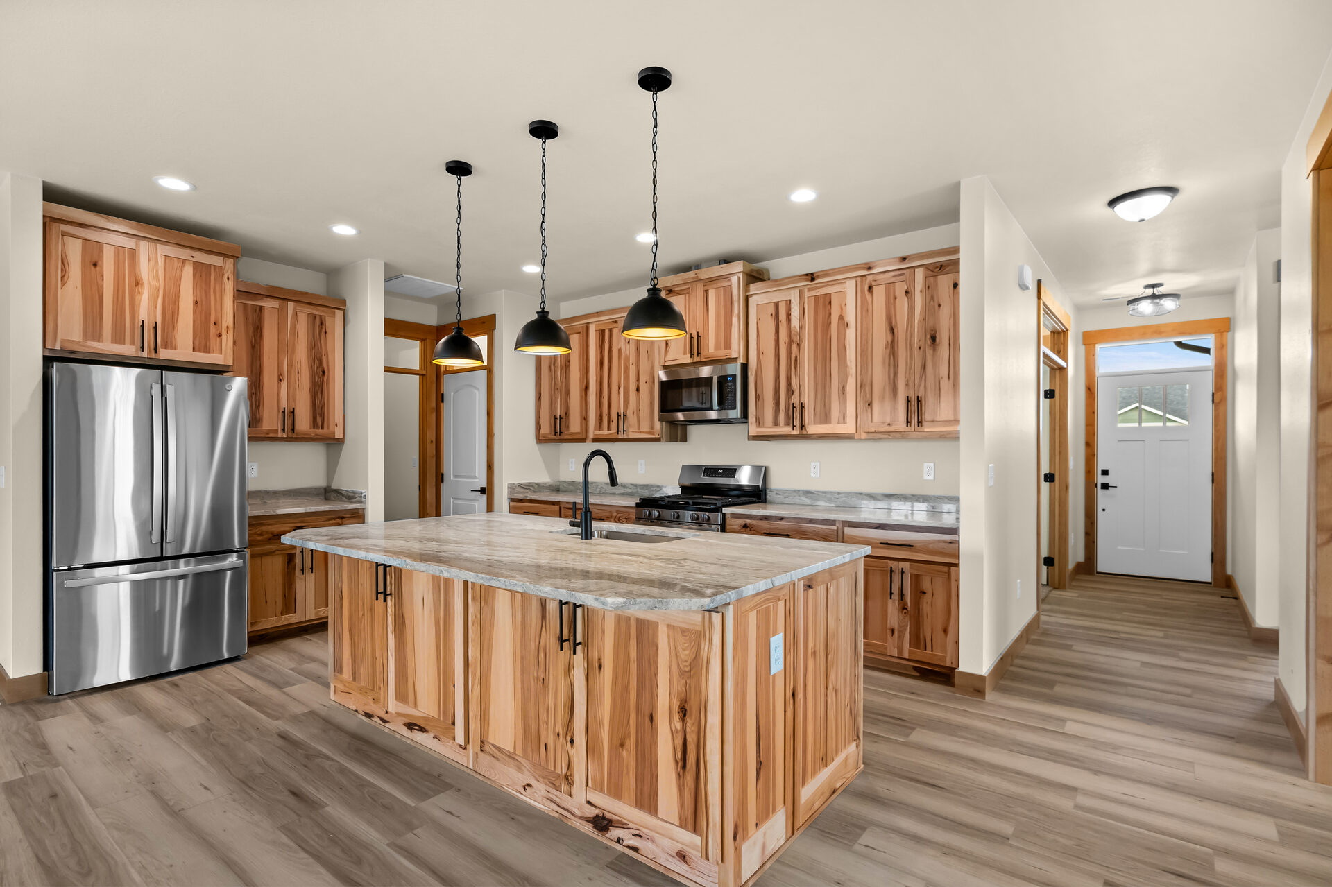 Kitchen and island viewed from the entry hallway at 3814 Lovegrass Ln